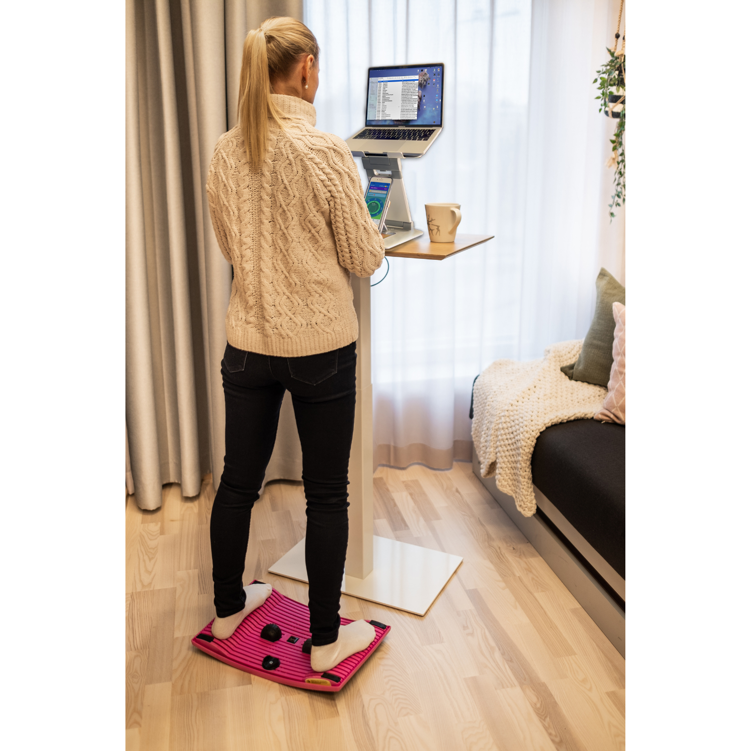 Woman using the pink Gymba Board and her Laptop Tower Stand 2.0